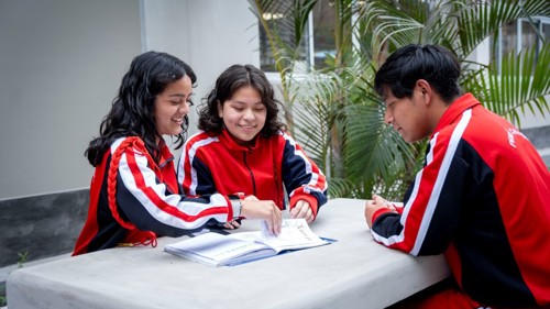 A group of school students looking a a text book